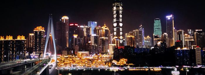 Illuminated buildings in city against sky at night