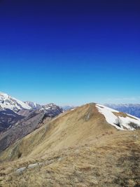 Scenic view of snowcapped mountains against clear blue sky