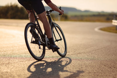 Low section of man riding bicycle on street