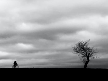 Silhouette of person on field against sky