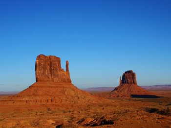 Scenic view of desert against clear blue sky