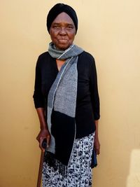 Portrait of woman standing against wall