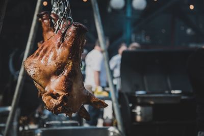 Close-up of roasted meat hanging in kitchen