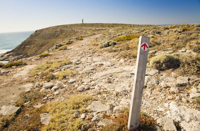 Arrow on signpost points the direction along the cliffs to the distant lighthouse