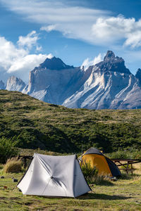 Tent on field against mountain range against sky