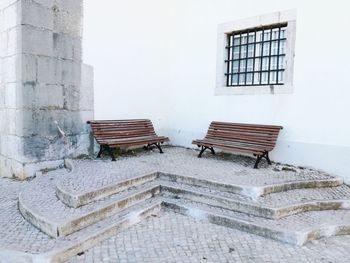 Empty bench against building
