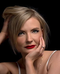 Close-up portrait of a beautiful young woman over black background