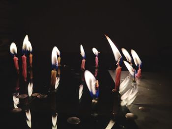 Close-up of lit candles in darkroom