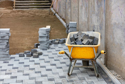 A yellow old construction wheelbarrow full of paving slab elements. copy space.