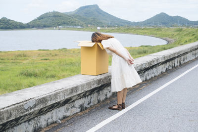 Woman standing on road by mountain