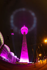 Low angle view of illuminated tower at night