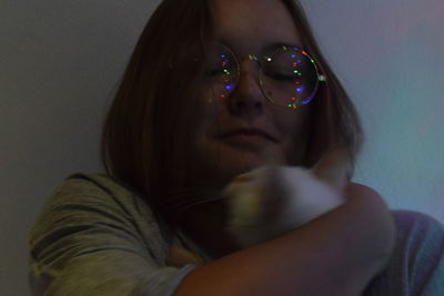 Portrait of woman sitting against wall