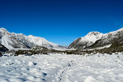 Scenic view of snowcapped mountains against clear blue sky