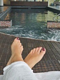 Low section of woman relaxing in swimming pool