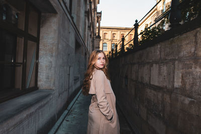 Full length portrait of woman standing on cobblestone