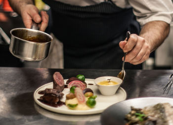 Midsection of man preparing food on table