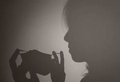 Close-up portrait of silhouette woman against wall, always wear mask to protect yourself