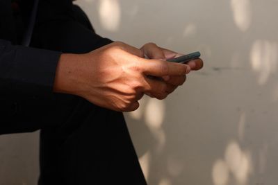 Midsection of man using mobile phone