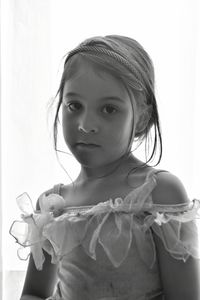 Portrait of cute girl standing against wall