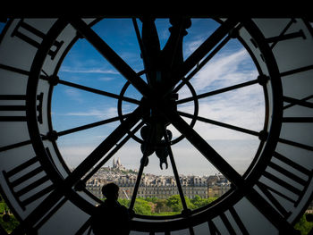 Silhouette of building against cloudy sky seen through window
