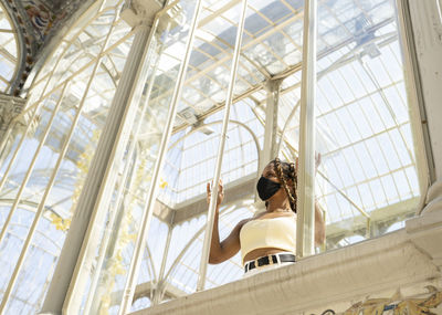 Low angle view of woman sitting at window