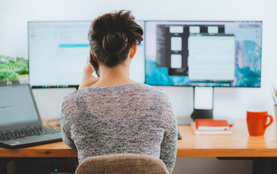 Rear view of woman using laptop