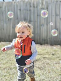 Toddler boy outside chasing bubbles