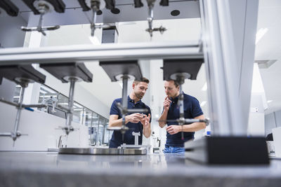 Two men at a machine in testing instrument room