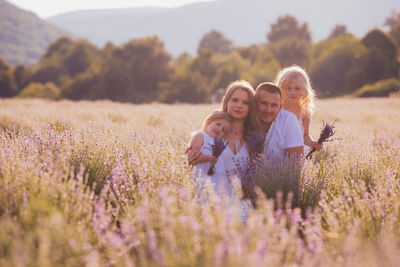 Cheerful family on flowering field