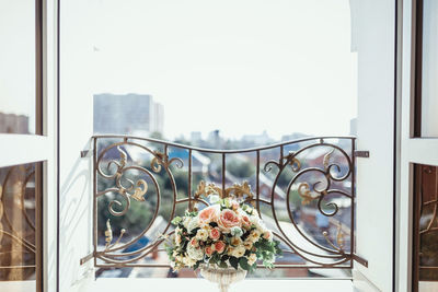 A flowerpot with flower arrangements of pink and white roses, white hydrangea and sprigs of greenery