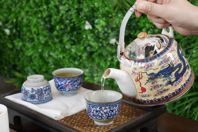 Hand holding tea cup on table