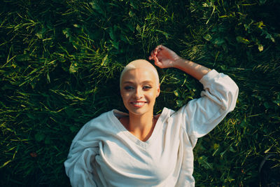 Portrait of young woman standing against plants