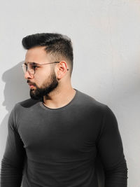 Young man standing against wall