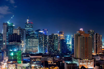 Illuminated buildings in city against sky at night