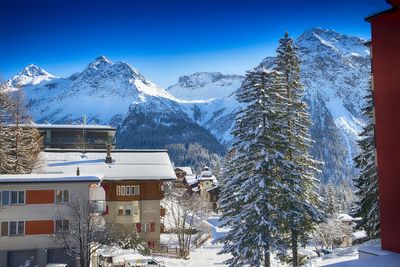 Snow covered houses and trees against clear sky