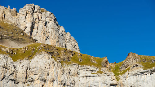 Low angle view of rocks against blue sky