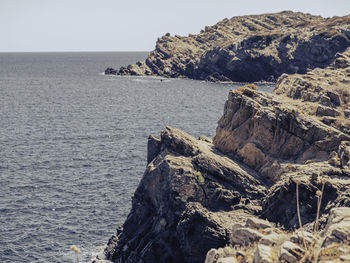 Rock formations by sea against sky