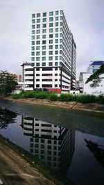 Reflection of building in canal against sky