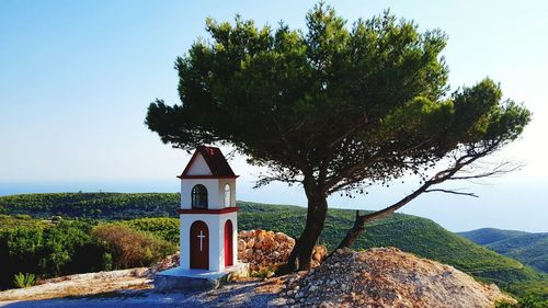 Chapel by tree against clear sky