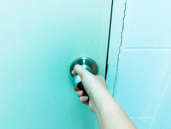 Close-up of hand holding blue door