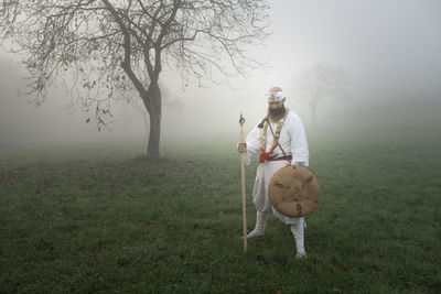 Full length of friends on field during foggy weather