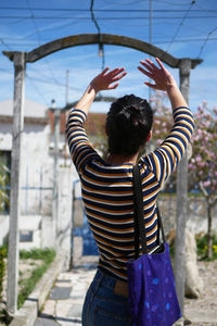 Young woman standing with arms raised in terrace