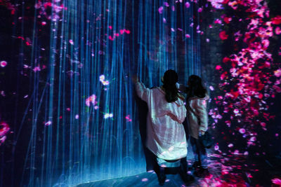 Rear view of couple standing at night