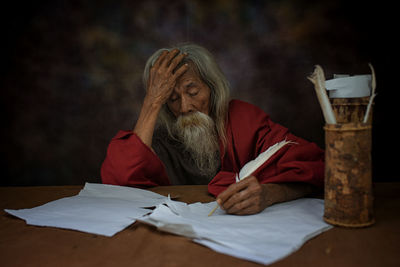 Portrait of man reading book on table