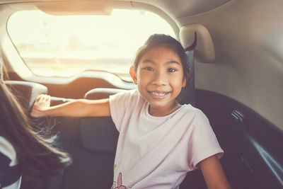Portrait of happy girl sitting in car