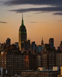 Modern buildings against sky during sunset