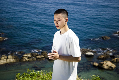 Young man sanding on beach