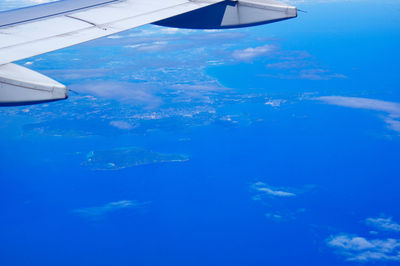 Aerial view of airplane wing over sea