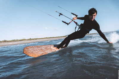 Man jumping in sea against clear sky