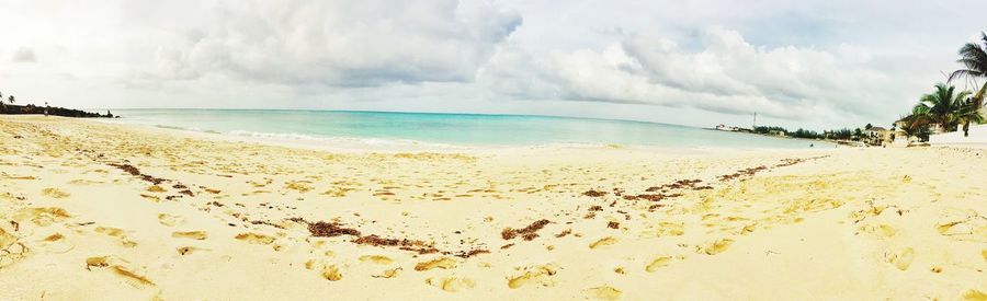 Scenic view of beach against cloudy sky